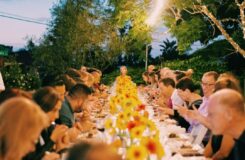 Große Gesellschaft bei einem festlich gedeckten Abendessen im Garten