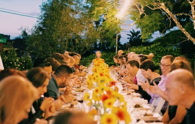 Große Gesellschaft bei einem festlich gedeckten Abendessen im Garten