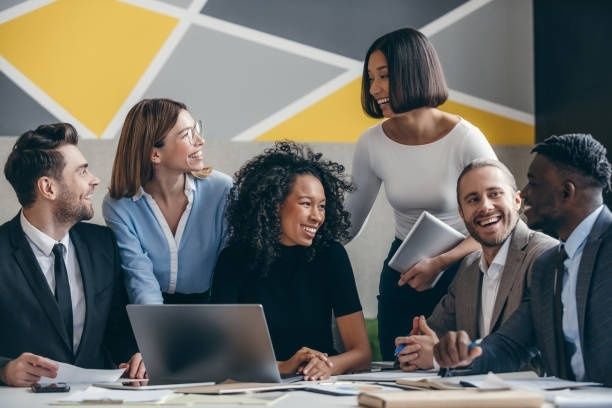 Diverses Team tauscht sich bei einem Meeting an einem Tisch aus